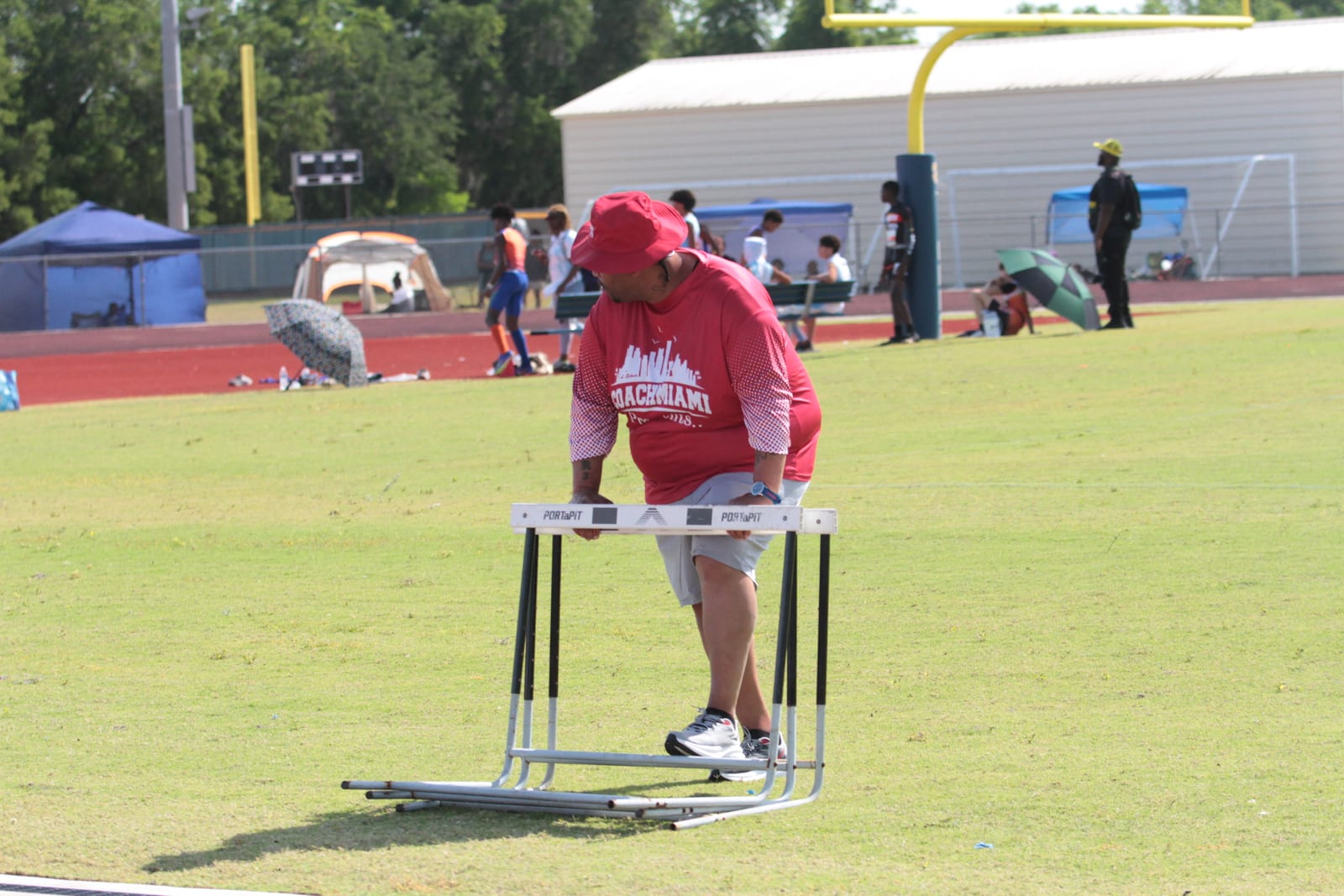 Coach setting hurdles on the track